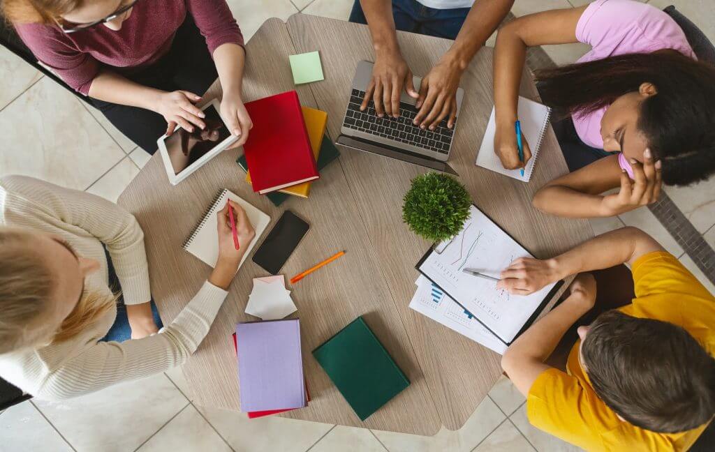 Group of international students sitting at table, top view